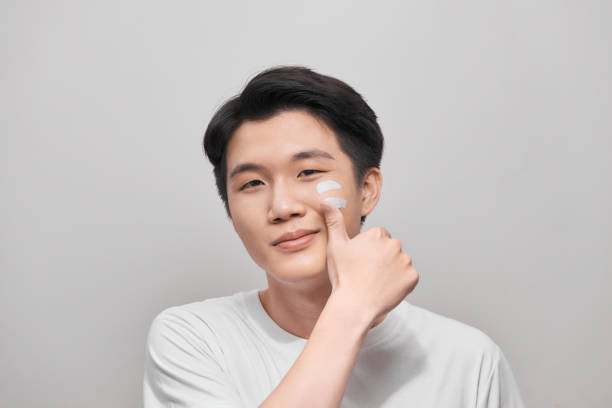 Men's skincare routine applying solar defence moisturizer to face